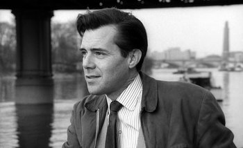 Movie still from “Darling” (1965), directed by John Schlesinger – Black and white photograph of a man wearing a jacket and tie; Close Up shot, Low angle