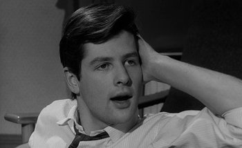 Movie still from “Darling” (1965), directed by John Schlesinger – A young man with his hand up to his head; Close Up shot, Over the shoulder angle