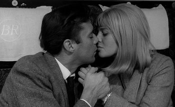 Movie still from “Darling” (1965), directed by John Schlesinger – A man and a woman kissing each other; Close Up shot, High angle