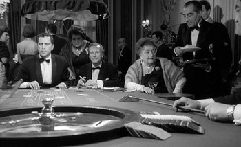 Movie still from “Darling” (1965), directed by John Schlesinger – A group of people sitting around a table; Medium shot, High angle