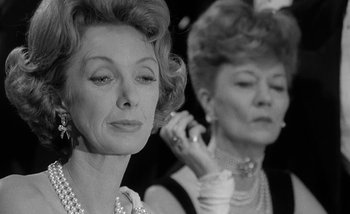 Movie still from “Darling” (1965), directed by John Schlesinger – Two older women wearing pearl necklaces and pearl earrings; Close Up shot, Low angle