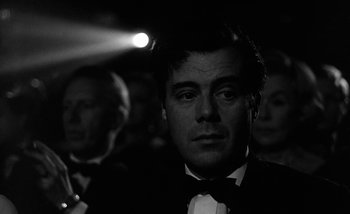 Movie still from “Darling” (1965), directed by John Schlesinger – A black and white photo of a man in a tuxedo; Close Up shot, Low angle