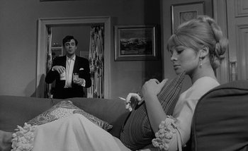 Movie still from “Darling” (1965), directed by John Schlesinger – A man and a woman sitting in a living room; Medium shot, Low angle