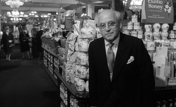 Movie still from “Darling” (1965), directed by John Schlesinger – An older man in a suit and tie standing in a store; Medium shot, Low angle