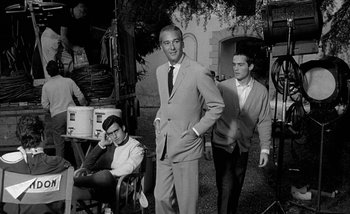 Movie still from “Darling” (1965), directed by John Schlesinger – A black and white photo of a man in a suit and tie; Medium shot, Low angle