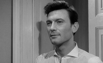 Movie still from “Darling” (1965), directed by John Schlesinger – Black and white photograph of a man in a striped shirt; Close Up shot, Over the shoulder angle