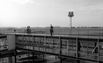 Movie still from “Darling” (1965), directed by John Schlesinger – A man and a woman standing on a bridge; Extreme Wide shot, Low angle