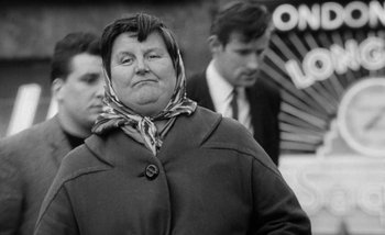 Movie still from “Darling” (1965), directed by John Schlesinger – An older woman wearing a coat and a neck scarf; Close Up shot, Low angle