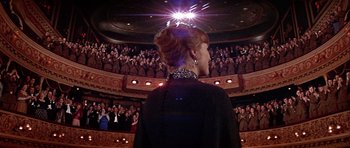 Movie still from “Darling Lili” (1970), directed by Blake Edwards – A woman standing in front of an audience in a theater; Wide shot, Low angle