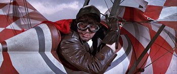Movie still from “Darling Lili” (1970), directed by Blake Edwards – A man wearing a brown leather jacket and a hat; Medium shot, Low angle