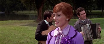 Movie still from “Darling Lili” (1970), directed by Blake Edwards – A woman in a purple dress and a man in a suit; Medium shot, Over the shoulder angle