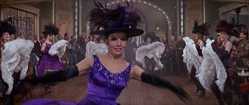 Movie still from “Darling Lili” (1970), directed by Blake Edwards – A woman wearing a purple dress and a purple hat; Medium shot, Low angle
