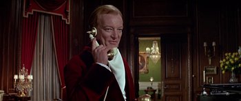 Movie still from “Darling Lili” (1970), directed by Blake Edwards – A man holding a phone up to his ear while standing in front of a mirror; Close Up shot, Low angle