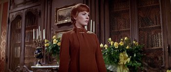 Movie still from “Darling Lili” (1970), directed by Blake Edwards – A woman standing in front of a wall with yellow flowers; Medium shot, Low angle