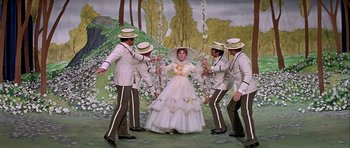 Movie still from “Darling Lili” (1970), directed by Blake Edwards – A group of men and a woman on a swing; Wide shot, Overhead angle