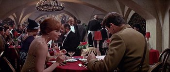 Movie still from “Darling Lili” (1970), directed by Blake Edwards – A man and a woman sitting at a dinner table; Medium shot, Over the shoulder angle