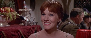 Movie still from “Darling Lili” (1970), directed by Blake Edwards – A person wearing a tiara and smiling; Close Up shot, Over the shoulder angle