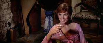Movie still from “Darling Lili” (1970), directed by Blake Edwards – A beautiful woman holding a glass of wine; Medium shot, Over the shoulder angle