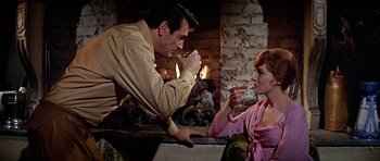 Movie still from “Darling Lili” (1970), directed by Blake Edwards – A man and a woman are drinking wine in front of a fireplace; Medium shot, Over the shoulder angle