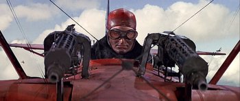 Movie still from “Darling Lili” (1970), directed by Blake Edwards – A man wearing a red helmet and goggles in an airplane; Medium shot, Low angle