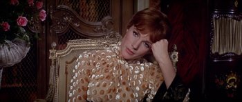 Movie still from “Darling Lili” (1970), directed by Blake Edwards – A woman sitting on top of a couch in a living room; Close Up shot, High angle