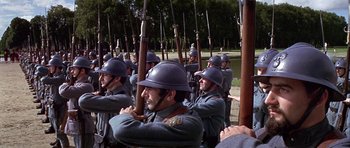 Movie still from “Darling Lili” (1970), directed by Blake Edwards – A group of men standing next to each other holding guns; Wide shot, High angle