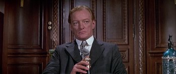 Movie still from “Darling Lili” (1970), directed by Blake Edwards – A person wearing a suit and tie; Close Up shot, Low angle