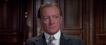 Movie still from “Darling Lili” (1970), directed by Blake Edwards – A person wearing a suit and tie; Close Up shot, Low angle