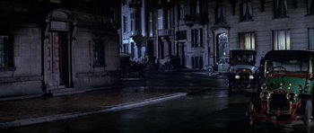 Movie still from “Darling Lili” (1970), directed by Blake Edwards – A street scene at night with cars parked on the side of the road; Extreme Wide shot, High angle
