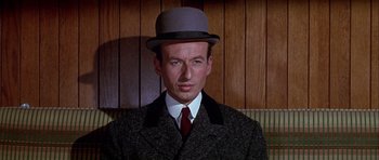 Movie still from “Darling Lili” (1970), directed by Blake Edwards – A man wearing a hat and a suit; Close Up shot, Low angle