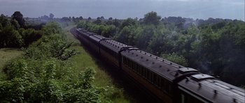 Movie still from “Darling Lili” (1970), directed by Blake Edwards – A train traveling down the tracks near a lush green field; Extreme Wide shot, High angle