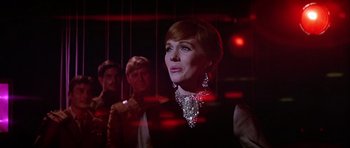 Movie still from “Darling Lili” (1970), directed by Blake Edwards – A woman in a black dress and a diamond necklace; Close Up shot, Low angle