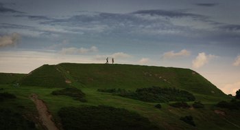 Movie still from “Dating Amber” (2020), directed by David Freyne – Two people standing on top of a green hill; Extreme Wide shot, Low angle
