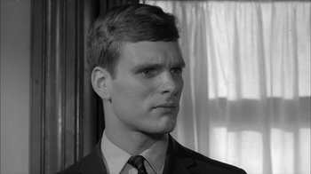 Movie still from “David and Lisa” (1962), directed by Frank Perry – A black and white photo of a man in a suit and tie; Close Up shot, Over the shoulder angle