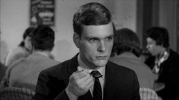 Movie still from “David and Lisa” (1962), directed by Frank Perry – A man in a suit and tie holding a tie; Close Up shot, Over the shoulder angle