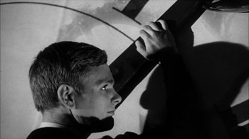 Movie still from “David and Lisa” (1962), directed by Frank Perry – A young man holding a cross over his shoulder; Close Up shot, Low angle