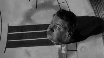 Movie still from “David and Lisa” (1962), directed by Frank Perry – A man is looking at the camera in a black and white photo; Medium shot, Overhead angle