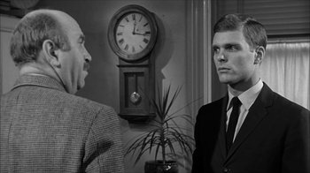 Movie still from “David and Lisa” (1962), directed by Frank Perry – Two men in a room with a clock on the wall behind them; Medium shot, Over the shoulder angle