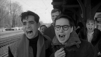 Movie still from “David and Lisa” (1962), directed by Frank Perry – Two young men are laughing together on a train; Medium shot, Low angle