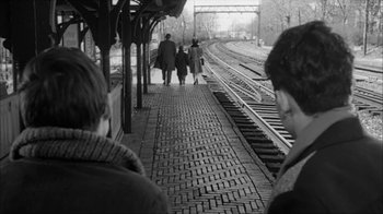 Movie still from “David and Lisa” (1962), directed by Frank Perry – A black and white photo of people walking along a train track; Wide shot, Over the shoulder angle