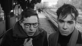 Movie still from “David and Lisa” (1962), directed by Frank Perry – Two young men standing next to each other on a train platform; Close Up shot, Over the shoulder angle