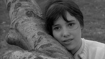 Movie still from “David and Lisa” (1962), directed by Frank Perry – A woman leaning against a tree with her head resting on the trunk of a tree; Close Up shot, High angle
