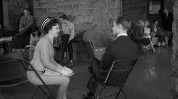 Movie still from “David and Lisa” (1962), directed by Frank Perry – A group of people sitting in chairs in a room; Wide shot, Over the shoulder angle