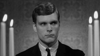 Movie still from “David and Lisa” (1962), directed by Frank Perry – A black and white photo of a man in a suit and tie; Close Up shot, Over the shoulder angle