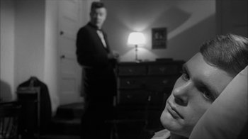 Movie still from “David and Lisa” (1962), directed by Frank Perry – A black and white photo of a man in a suit and tie; Close Up shot, Over the shoulder angle