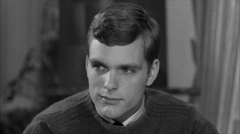 Movie still from “David and Lisa” (1962), directed by Frank Perry – A young man with short hair wearing a sweater and a tie; Close Up shot, Over the shoulder angle