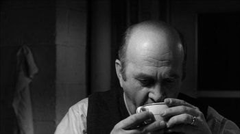Movie still from “David and Lisa” (1962), directed by Frank Perry – An older man is drinking from a cup; Close Up shot, High angle