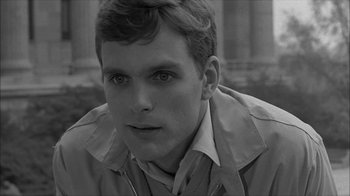Movie still from “David and Lisa” (1962), directed by Frank Perry – A young man in a trench coat looking at the camera; Close Up shot, High angle