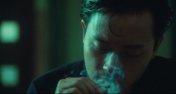 Movie still from “Days of Being Wild” (1990), directed by Kar-Wai Wong – A man is smoking a cigarette in a dark room; Close Up shot, Low angle