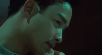 Movie still from “Days of Being Wild” (1990), directed by Kar-Wai Wong – A young man's face in a dimly - lit room; Close Up shot, Low angle